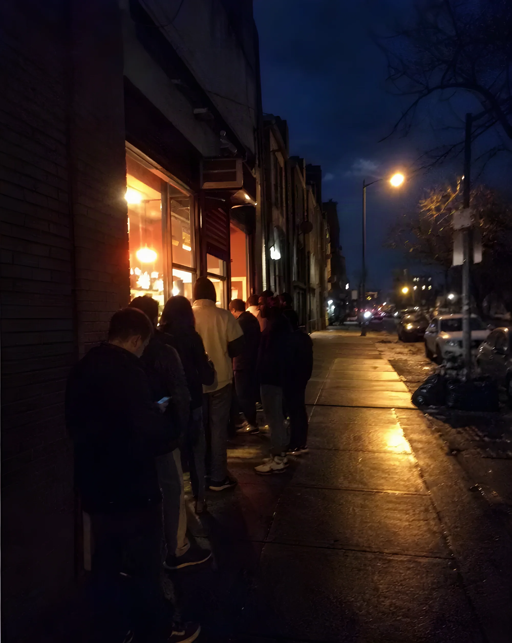 People waiting in line on the sidewalk after midnight