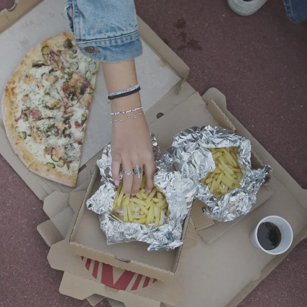 Foil-wrapped fries shared on the curb late at night