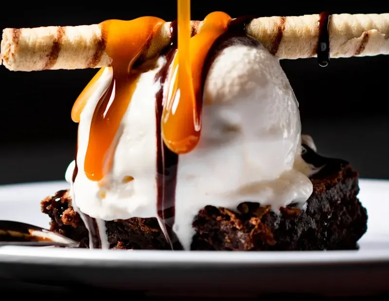 Brownie sundae with caramel poured over vanilla ice cream