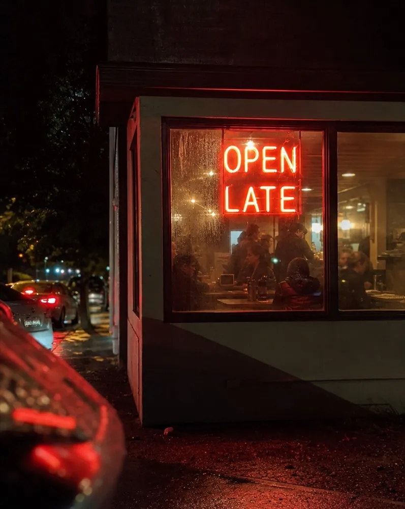 The open late neon glowing in the front window after midnight