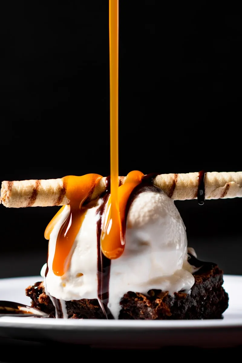 Brownie sundae with caramel poured over vanilla ice cream